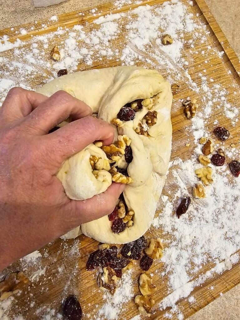 Cranberry walnut bread dough being mixed in a large bowl before rising.