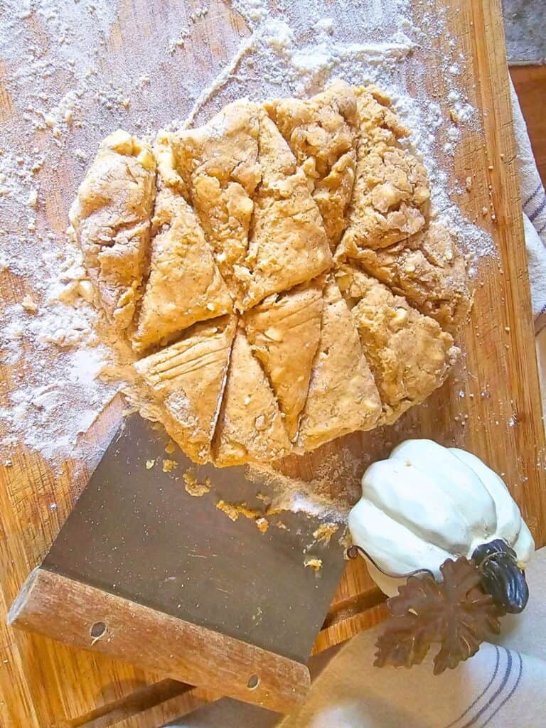 pumpkin scone dough being cut into triangles