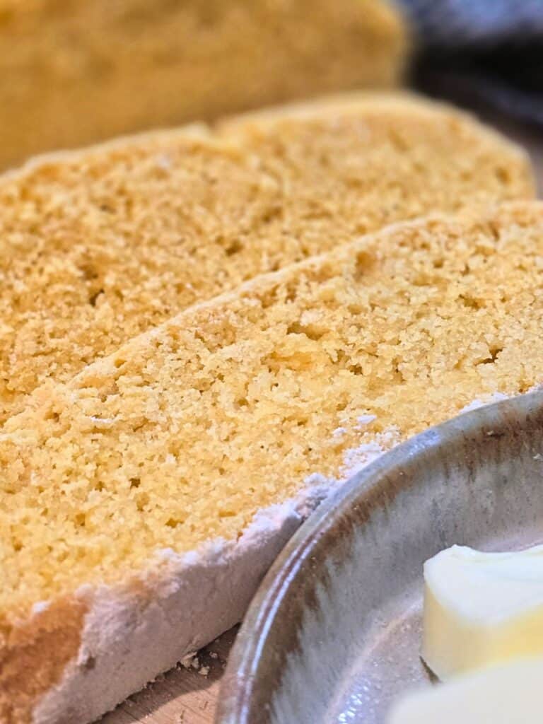 sliced homemade cornmeal bread with butter