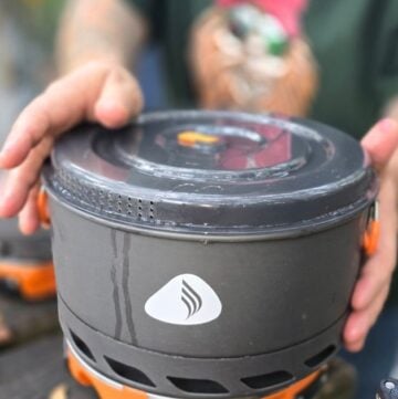 BEST CAR CAMPING PORTABLE KITCHEN THIS IS AN IMAGE OF A MAN HOLDING CAMP COOKWARE