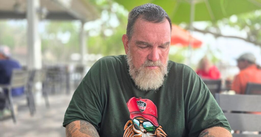 THIS IS AN IMAGE OF A MAN LOOKING AT THE MENU AT AUNT KATE'S