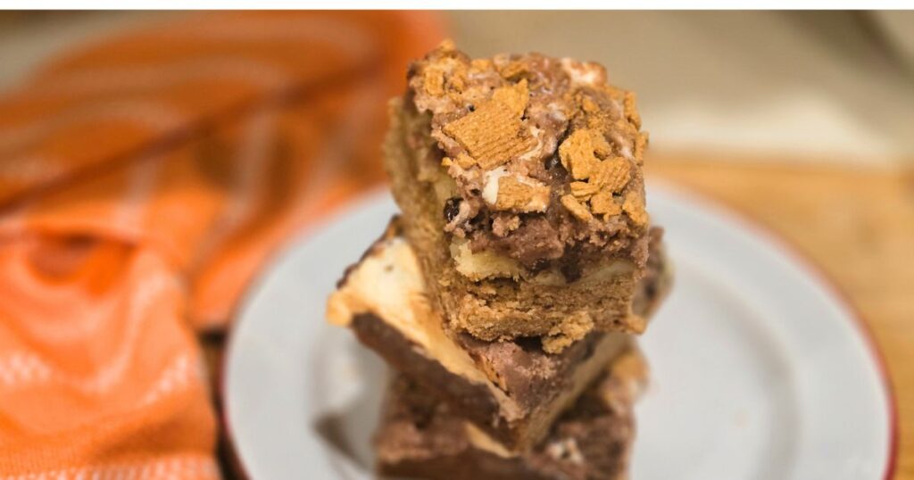 GOOEY S'MORES BAR RECIPE THIS IS AN IMAGE OF THE S'MORES BARS STACKED ON A PLATE
