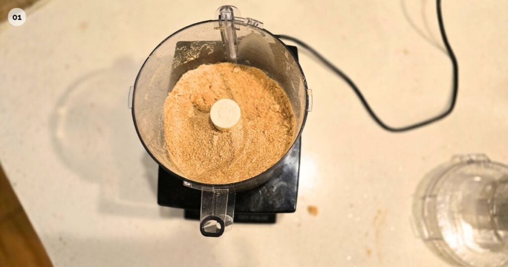 THIS IS AN IMAGE OF STEP ONE FOR GOOEY S'MORES BAR RECIPE GRAHAM CRUMBS IN A FOOD PROCESSEOR