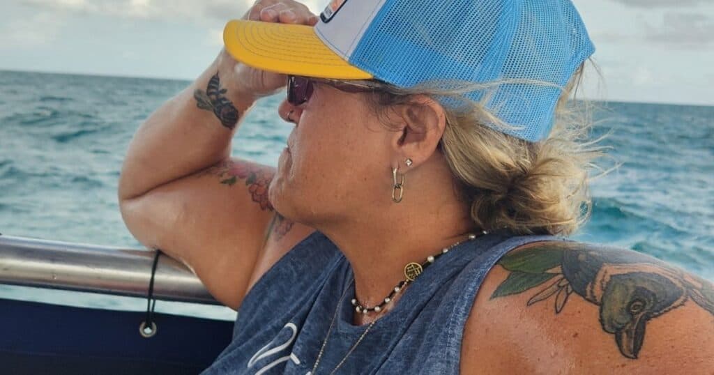 Outdoor adventures at John Pennekamp State Park Florida Keys WOMAN WITH BASEBALL CAP ON BACK OF BOAT