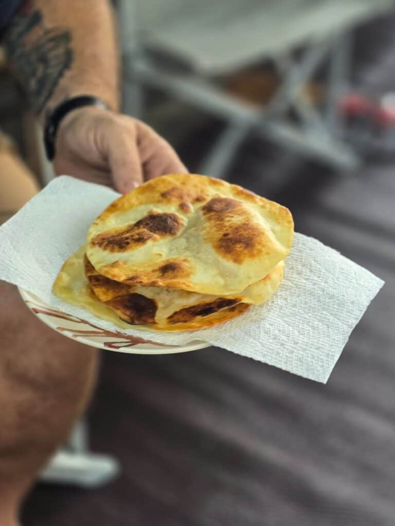 Reheating leftover mojo pork in a skillet for easy breakfast tostadas at the campsite