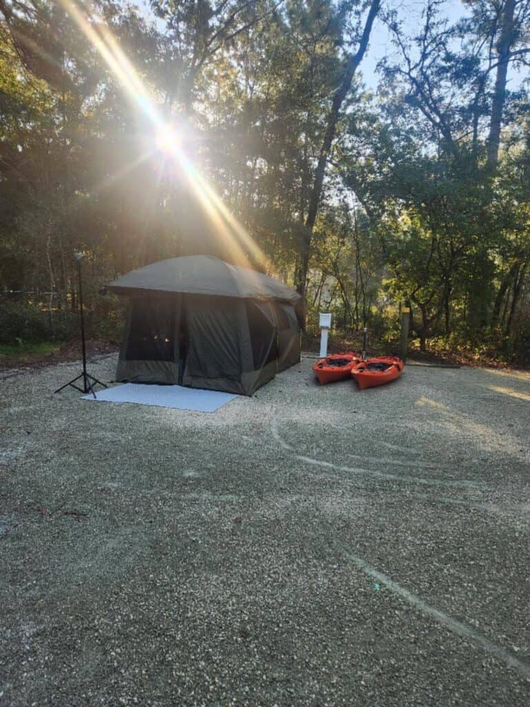 Sunrise camping scene at Silver Springs State Park featuring a tent and kayaks beside the water during an outdoor Florida camping and kayaking trip.
