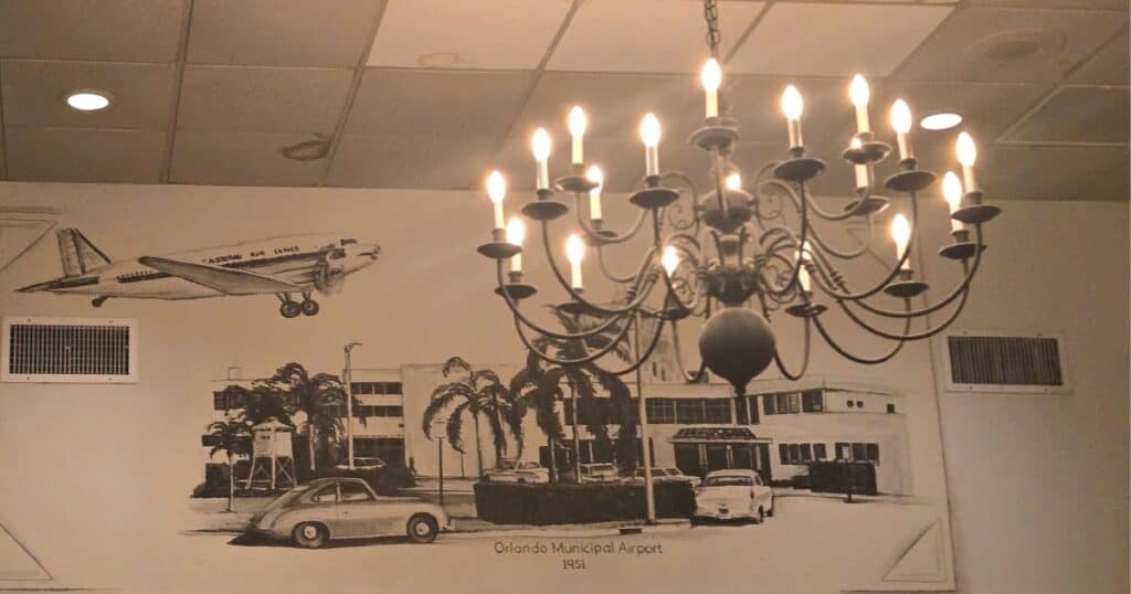 Busy dining room inside Linda’s La Cantina, an old-school Orlando steakhouse mural on wall with chandelier