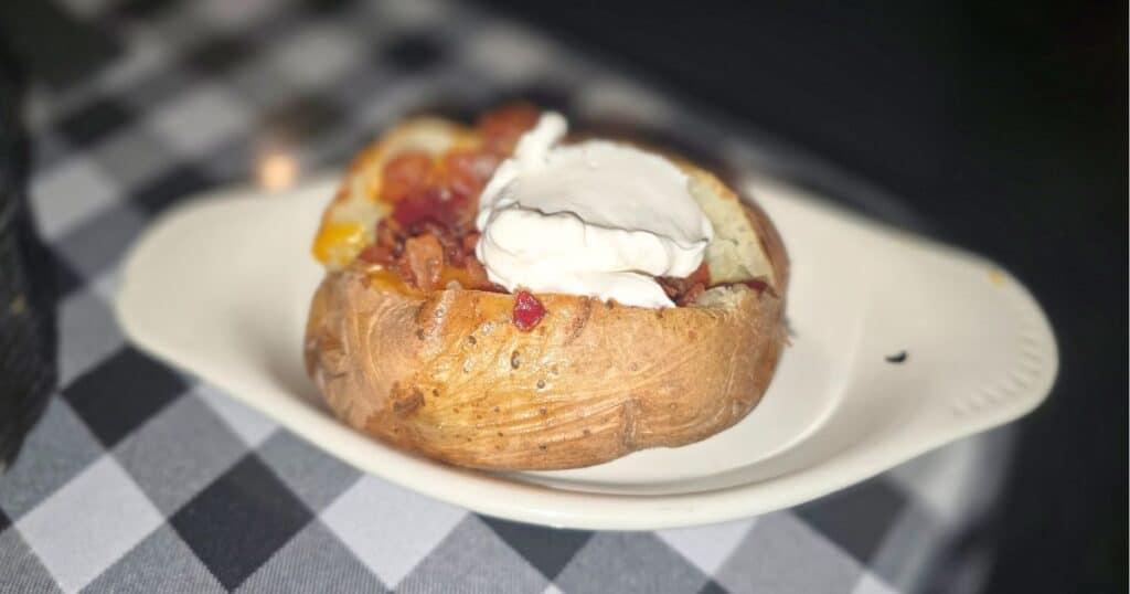 Loaded baked potato with cheese, bacon, sour cream, and chives